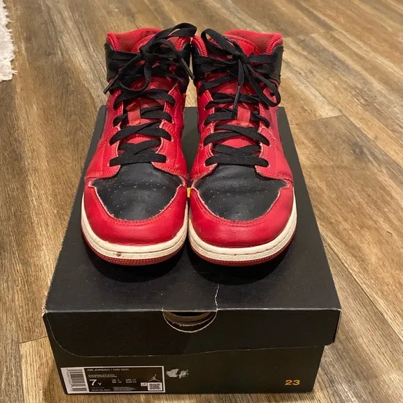 Youth red and black Nike Air Jordan high top sneakers
